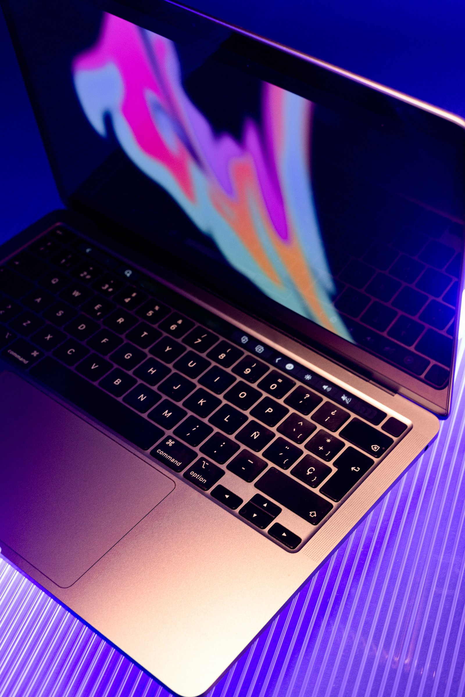 an apple laptop is shown on a purple background